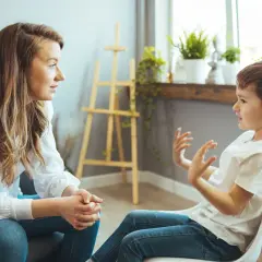 Kobieta i dziecko rozmawiają. To ważna rozmowa o tym, jak rozmawiać z dzieckiem o samobójstwie rodzica.