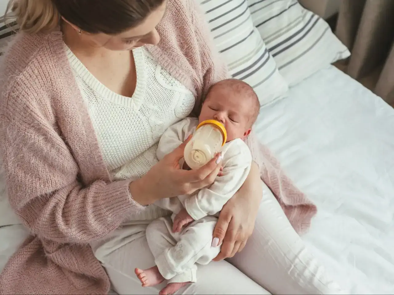Rodzic karmiący dziecko butelką z kaszką